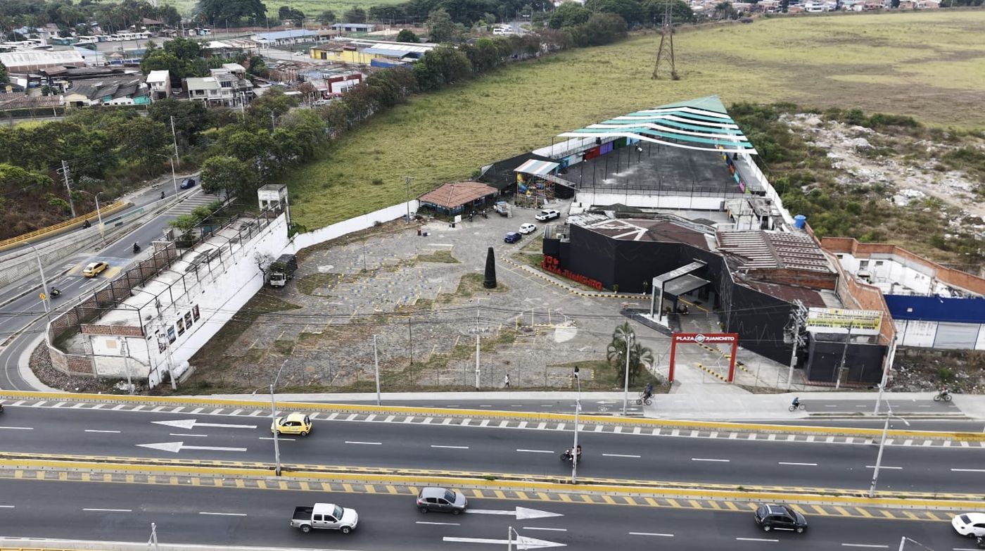 Vista aérea de día de Plaza Juanchito y su parqueadero junto a la vía
